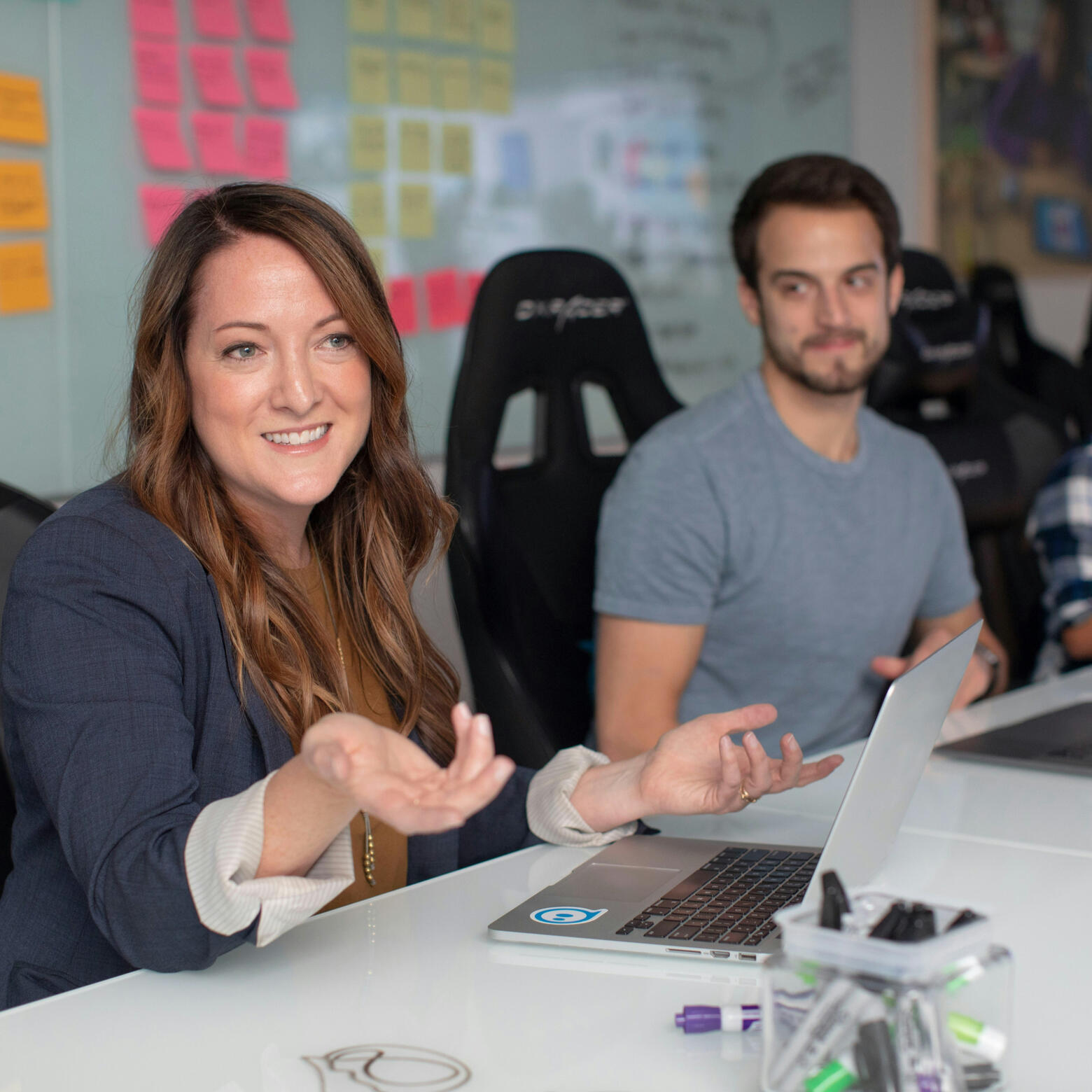 A group of women sitting at a table looking at each other and smiling broadly